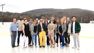 A group of people standing on a rooftop|||Aerial photo of large industrial building with mountains in the background